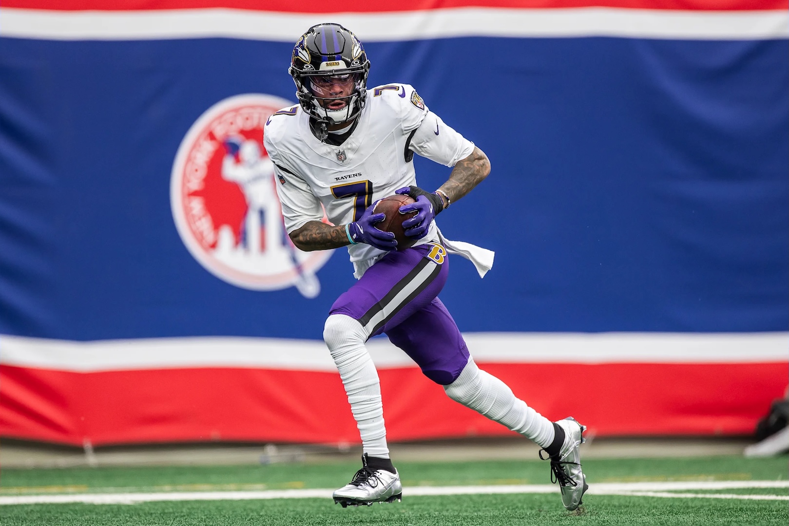 Baltimore Ravens wide receiver Rashod Bateman runs with the football during an NFL game.