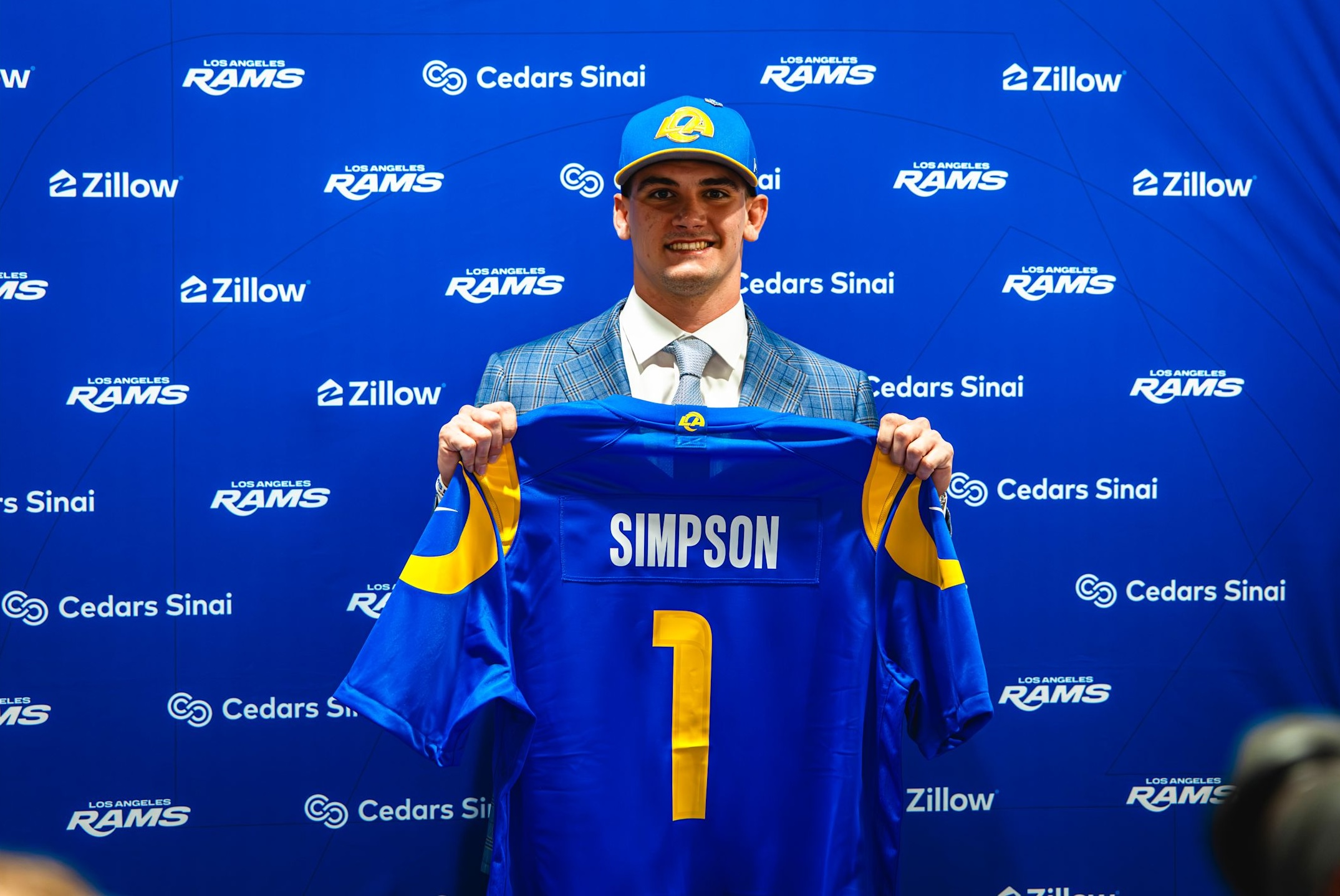 Rams first-round pick Ty Simpson poses with his jersey in his first press conference with the team.